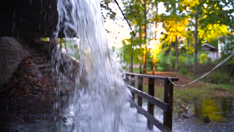 Fresh-cool-water-falling-down-in-local-park-on-sunny-evening-time,-close-up-view
