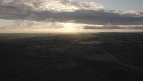 Drone-flying-sideways-over-beautiful-Italian-landscape-at-sunrise-with-rays-of-light-breaking-through-the-clouds-in-4k