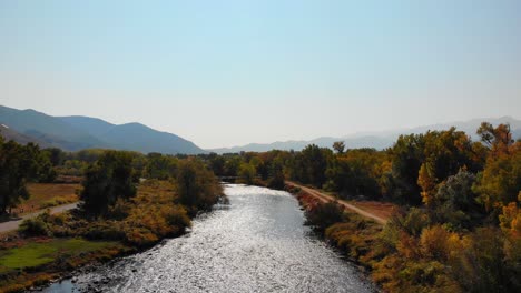 Autumn-Fall-River-Flowing-in-Mountainous-Valley-With-Lush-Yellow-Foliage-Near-Rocky-Mountains,-Colorado,-USA