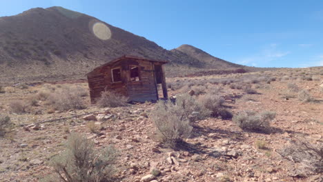 Panning-shot-of-an-outhouse-ruin-in-the-Arizona-desert