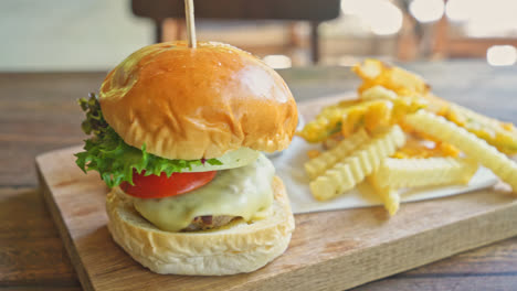 beef-burger-with-cheese-and-potato-chips-on-wood-tray