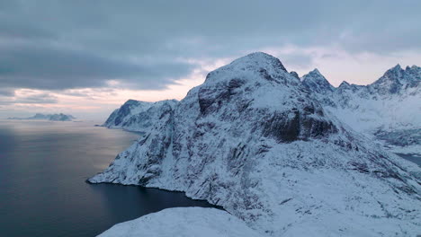 Extreme-Lofoten-islands-wintry-frozen-mountain-and-blue-ocean-landscape-aerial-view-dolly-right