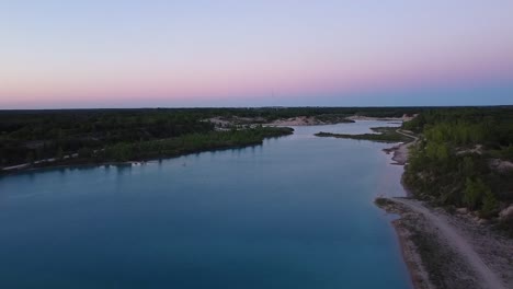 Aerial-Pan-up-to-Sunset-Over-Blue-Lake-in-Quarry