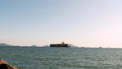 Fernsicht-Auf-Ein-Seefrachtschiff,-Das-Tagsüber-Intermodale-Container-Durch-Die-Ruhigen-Gewässer-Des-Panamakanals-Transportiert,-Mit-Einem-Klaren-Blauen-Himmel-Und-Milden-Winden,-Die-Zum-Pazifischen-Ozean-Kreuzen