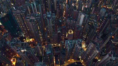 Drone-shot-of-a-city-full-of-skyscrapers-during-the-night,-a-lot-of-roads-with-busy-traffics