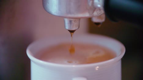 Coffeecup-with-espresso-maker-in-slow-motion