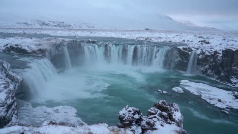 Panoramic-shot-of-spectacular-Godafoss-waterfall-in-winter-landscape-of-Iceland