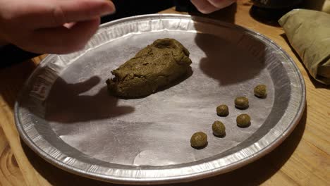 Making-little-pellets-from-Moringa-and-turmeric-powder-herbal-superfood-on-silver-tray