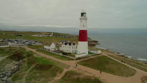 Aerial-view-Portland-Bill-striped-lighthouse-on-rugged-English-Jurassic-coastline-Dorset-dolly-right