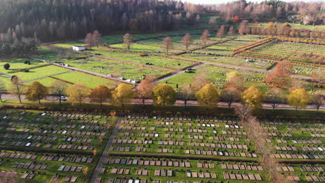 Aerial-flyover-peaceful-Kviberg-Cemetery-with-colorful-trees-in-autumn