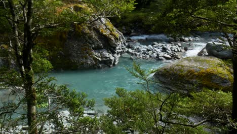 Slowly-floating-tropical-river-surrounded-by-rocky-shore-and-trees-in-National-Park