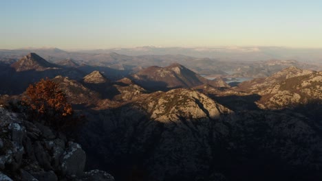 AERIAL---Mountains-and-valley-around-Lake-Skadar,-Montenegro,-wide-reverse-shot