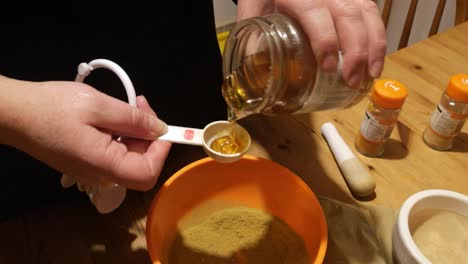 Female-measures-honey-with-Moringa-and-turmeric-powder-herbal-medicine-supplement-in-kitchen