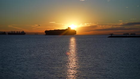 Silhouette-of-a-cargo-container-ship-in-the-harbor-amidst-a-global-supply-chain-crisis-at-sunset