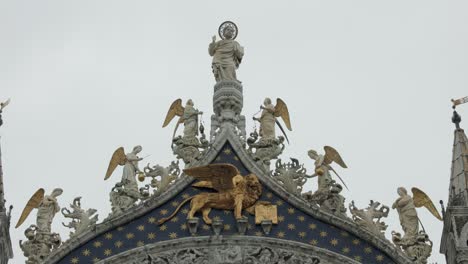 View-Of-Statues-Of-Winged-Lion,-Angels,-And-Jesus-Christ-On-The-Upper-Part-Of-The-Main-Entrance-Of-St