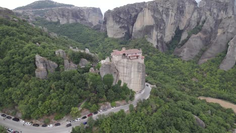 Mountain-road-circling-around-Monastery-of-Rousanou-on-top-of-rock,-Meteora,-Thessaly,-central-Greece