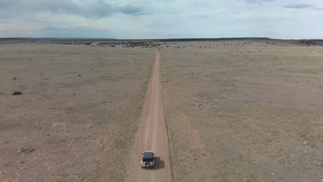 Tilt-shift-aerial-changes-perspective-following-jeep-on-desert-road