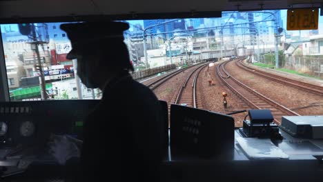 Zeitlupenaufnahme-Des-Lokführers,-Der-Den-Zug-Auf-Der-Eisenbahn-Auf-Einer-Langen-Reise-Bewegt,-Tokio,-Japan