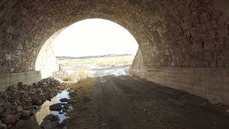Going-under-a-rock-bridge-on-an-abandoned-farm-land-in-Colorado