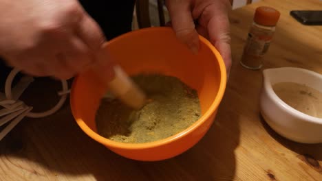 Blending-Moringa-and-ginger-powder-making-herbal-medicine-supplement-in-orange-bowl
