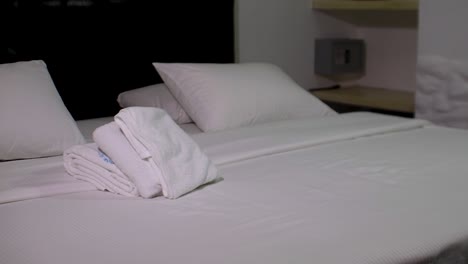 HOSTAL-CLEAN-BEDROOM-WHITE-SHEETS-AND-TOWELS-AND-SAFE-STRONGBOX,-CLOSE-UP-PAN-RIGHT