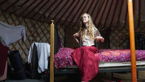 Weiblicher-Umweltbewusster-Hippie,-Der-Sich-Auf-Dem-Bett-In-Der-Jurte-Hinsetzt