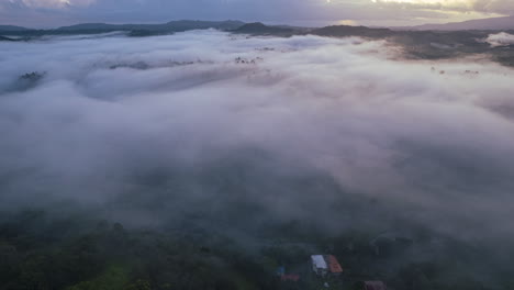 Impresionante-Niebla-De-Invierno-En-Un-Bosque-Con-Montañas-Con-El-Sol-Saliendo-A-Través-De-Las-Nubes