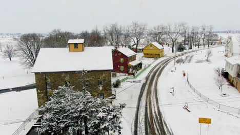 Traditional-mill-and-home,-barn-in-Lancaster-County-PA-during-winter-snowstorm