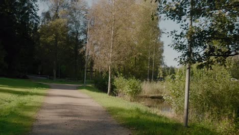 POV-Walking-To-The-Parking-Lot-of-Kypesjön,-Borås-Sweden,-Wide-Shot-Tracking-Forward