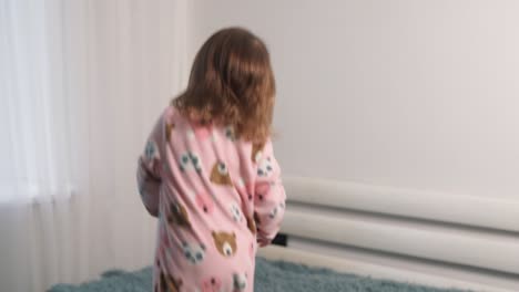Fröhliches-Zweijähriges-Mädchen-Springt-Auf-Das-Bett-Im-Schlafzimmer