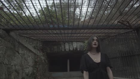 Slow-motion-portrait-of-a-goth-girl-inside-exterior-animal-cage