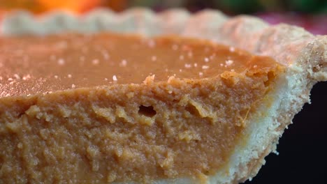 Close-up-of-a-slice-of-pumpkin-pie-with-fall-foliage