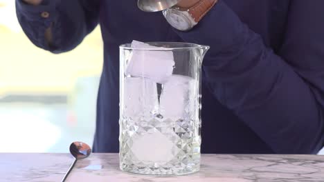 Barkeeper-Gießt-Alkoholgetränk-In-Ein-Glas-Mit-Eis