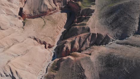 Flying-Drone-shot-above-desert-green-mounts,-Jurassic-park-look,-blue-sky