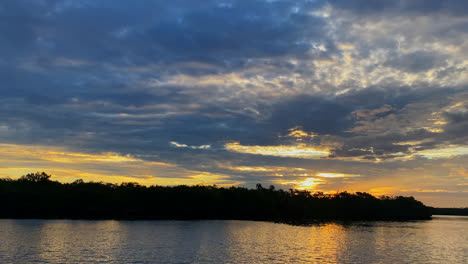 Filmische-Aufnahme-Eines-Wunderschönen-Sonnenaufganghimmels-über-Dem-Ozean-Und-Mangrovenwald-An-Der-Kakerlakenbucht,-Die-Sich-Im-Hintergrund-Abhebt