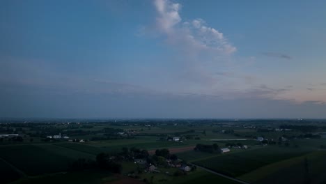An-aerial-view-of-the-lush-green-farmlands-in-the-rural-countryside-of-Lancaster-County,-Pennsylvania-in-the-last-light-of-the-day