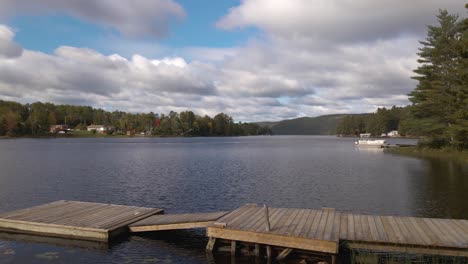 A-beautiful-day-at-a-cottage-in-rural-Canada-with-a-large-dock-leading-up-to-a-lake-during-the-summer