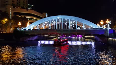 Puente-Elgin-En-Singapur-Por-La-Noche-Con-Bumboat-Y-Luces-Nocturnas-De-Deportistas-Durante-El-Bicentenario-De-Singapur