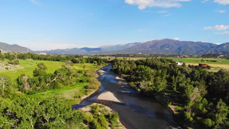 Seichte-Flusslandschaft,-Gesäumt-Von-Lebhaften,-üppig-Grünen-Bäumen-Im-Felsigen-Bergtal-Von-Colorado