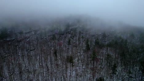 Aerial-drone-video-footage-of-a-beautiful-snowy,-foggy-evening-with-low-clouds-in-the-Appalachian-mountains-during-winter