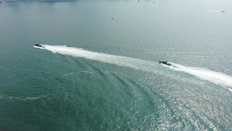 Hong-Kong-coastguard-boats-roaring-across-the-open-bay-waters,-Aerial-view