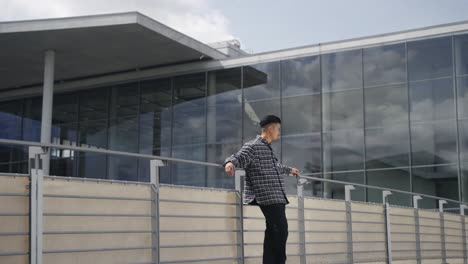 Confident-asian-male-model-posing-in-front-of-modern-architecture