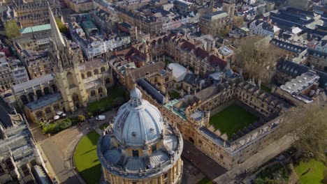 University-of-Oxford,-sweeping-aerial-reveal-passing-the-Church-of-Saint-Mary-the-Virgin-and-the-Radcliffe-Camera-Library