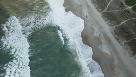 Aerial-tilt-reveal-Wrightsville-Beach-shoreline,-North-Carolina