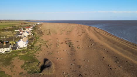 Row-of-remote-houses-Aerial-image-shingle-street-Suffolk-bright-sunny-day