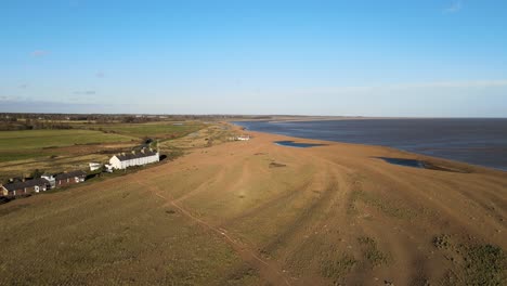 Row-of-old-coastguard-cottages-Aerial-drone-view-shingle-street-Suffolk-bright-sunny-day