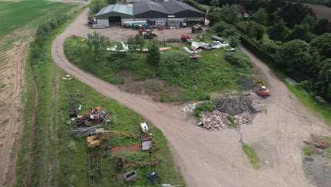 Aerial-establishing-shot-of-the-vintage-military-jets-graveyard-in-the-rural-area-in-Worcestershire,-UK