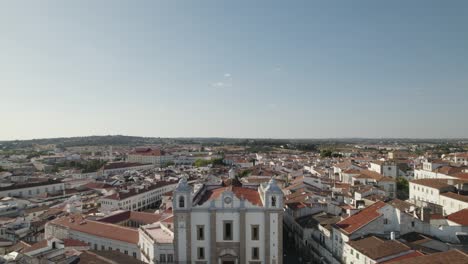 Aerial-pullback-reveal-Santo-Antão-Church,-Evora-Famous-Giraldo-Square,-Alentejo