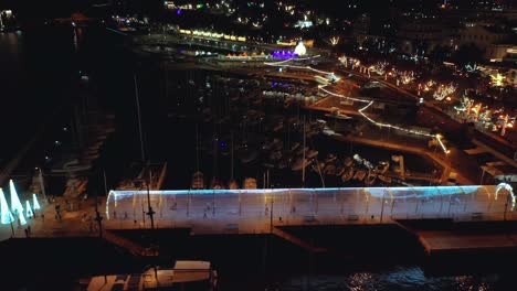 Christmas-light-art-exhibition-with-colorful-illuminated-tube-at-Funchal-marina,-aerial