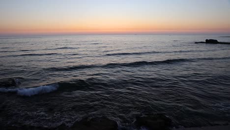 Entspannende-Szene-Von-Meereswellen,-Die-Am-Ufer-Zusammenbrechen,-Mit-Einem-Wunderschönen-Sonnenuntergang-Am-Horizont
